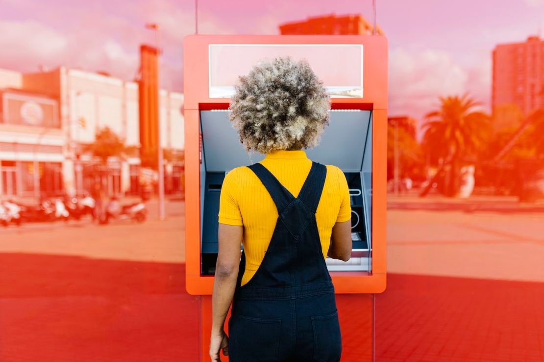 Person using a bright red ATM.