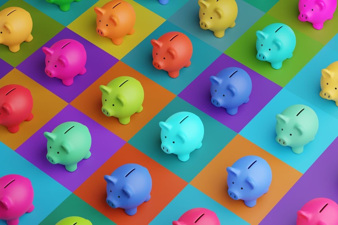 A photo of piggy banks in multiple colors on a multi-colored checkered background